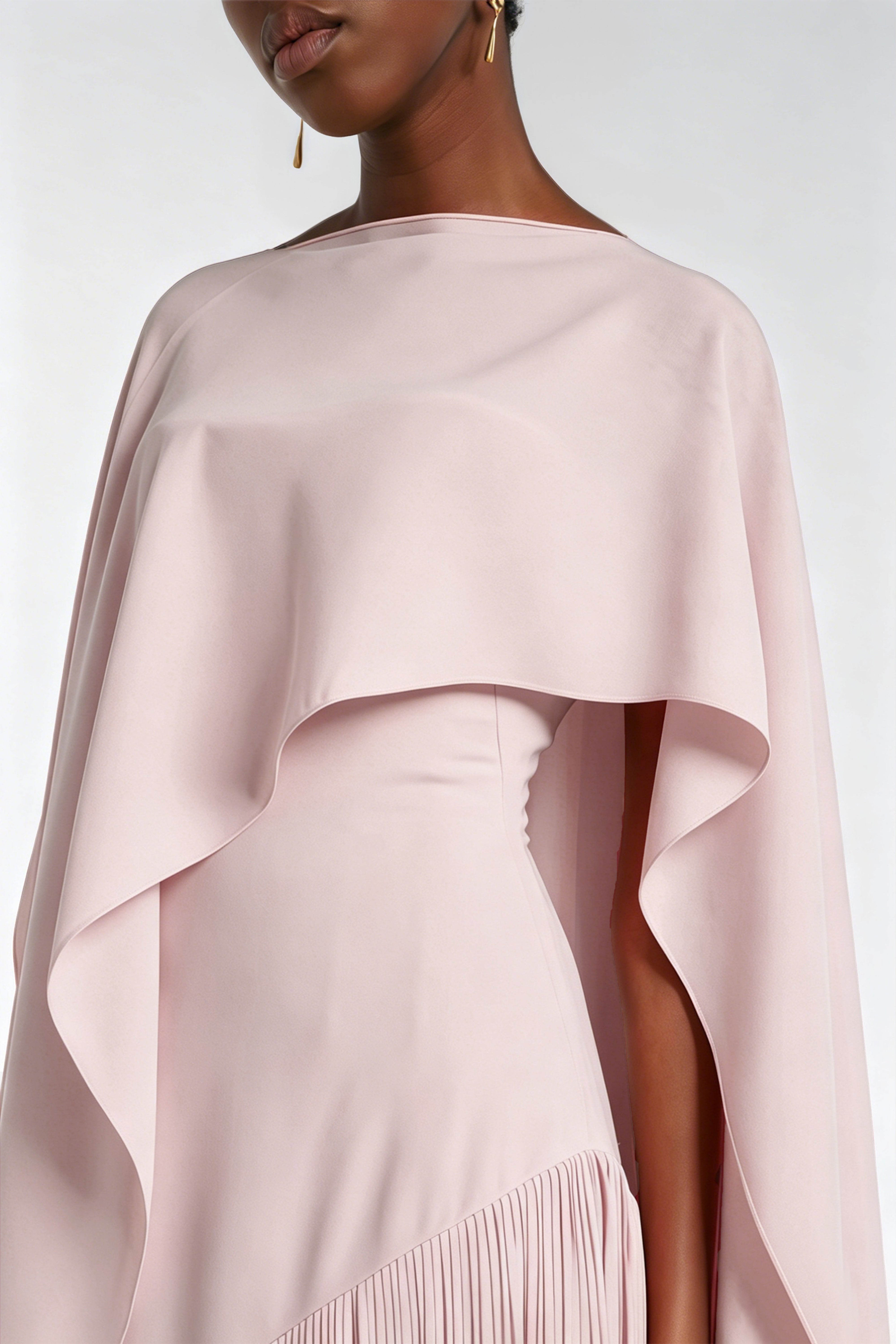 Light pink cape maxi dress with an asymmetrical waist and long fringe skirt