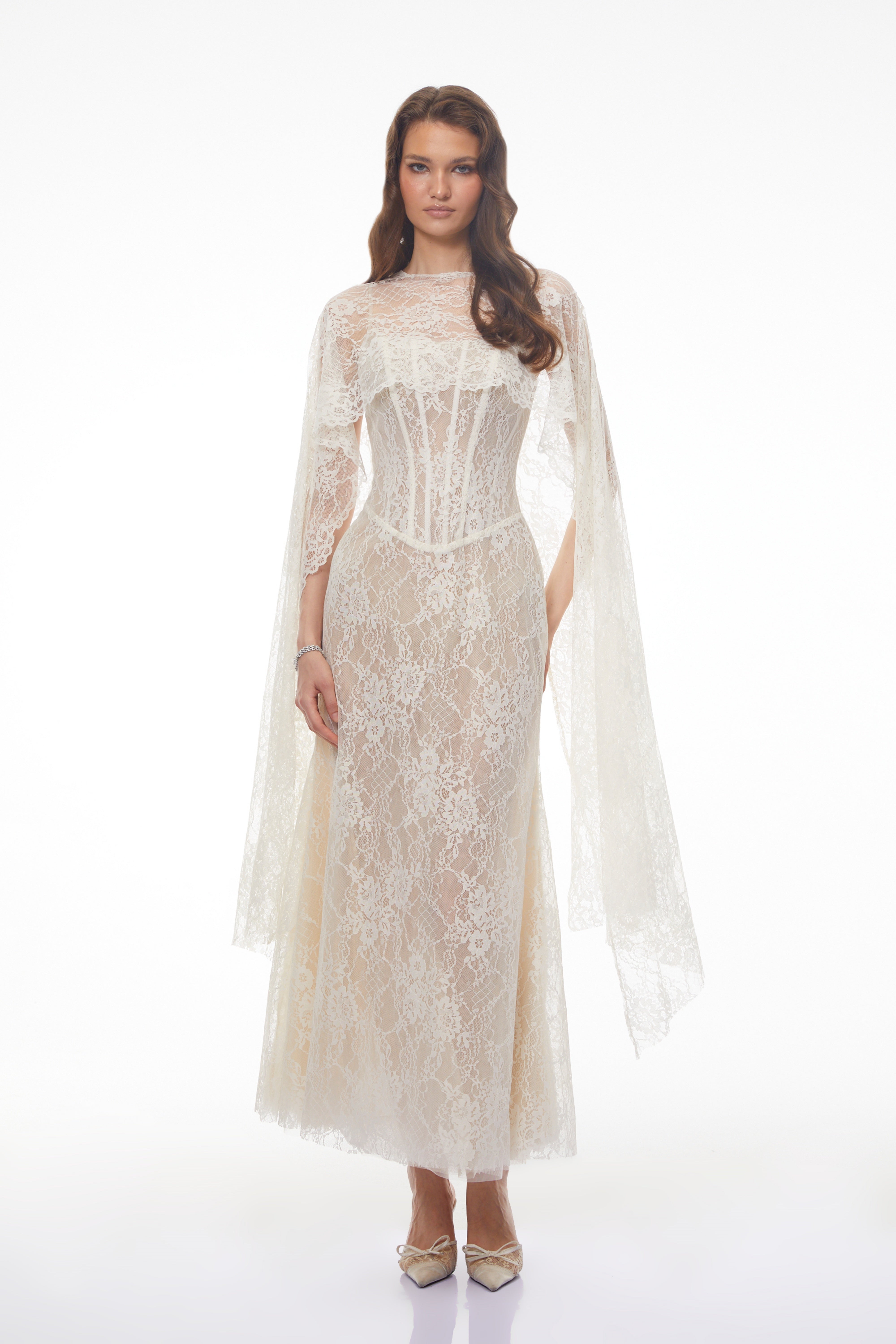 White lace maxi dress with a corset bodice, high neckline, and long draped cape sleeves