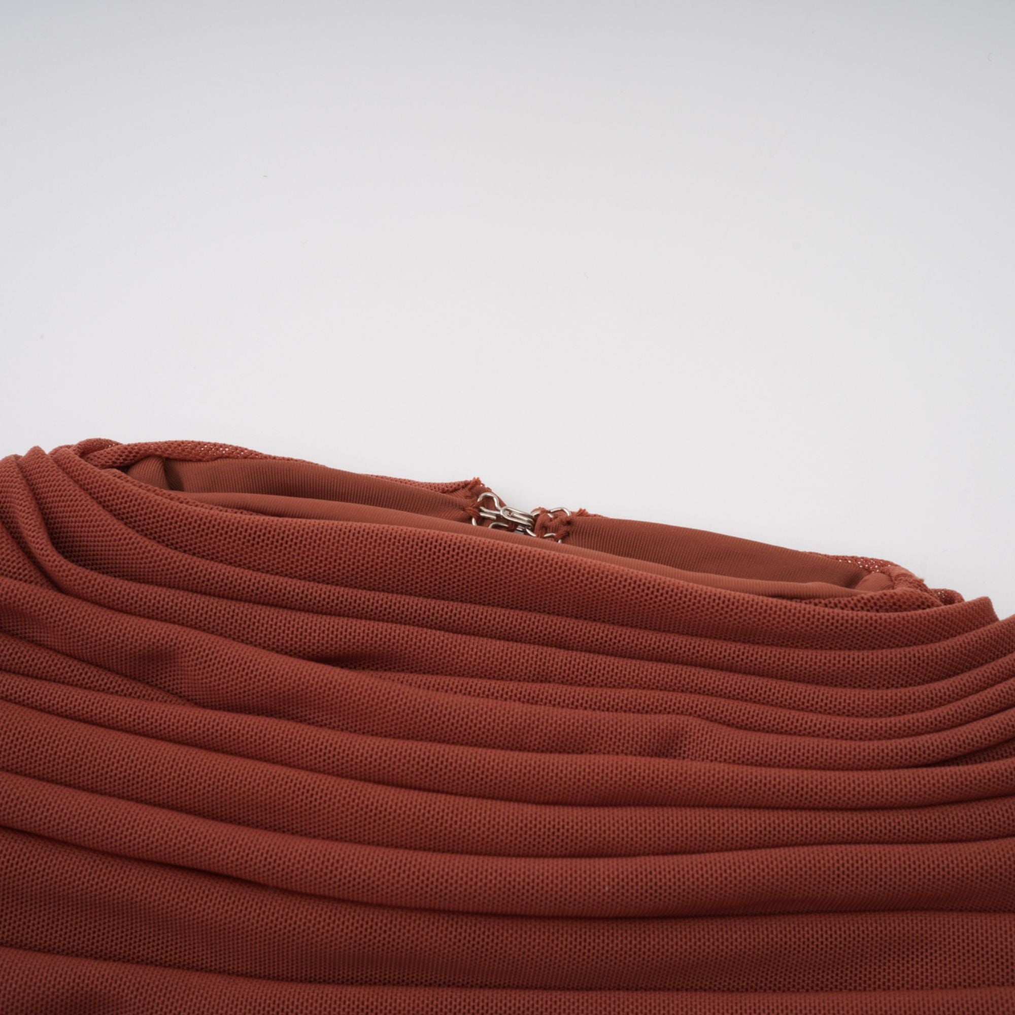 Rust-colored long-sleeve maxi dress with a draped cowl neckline and pleated bodice