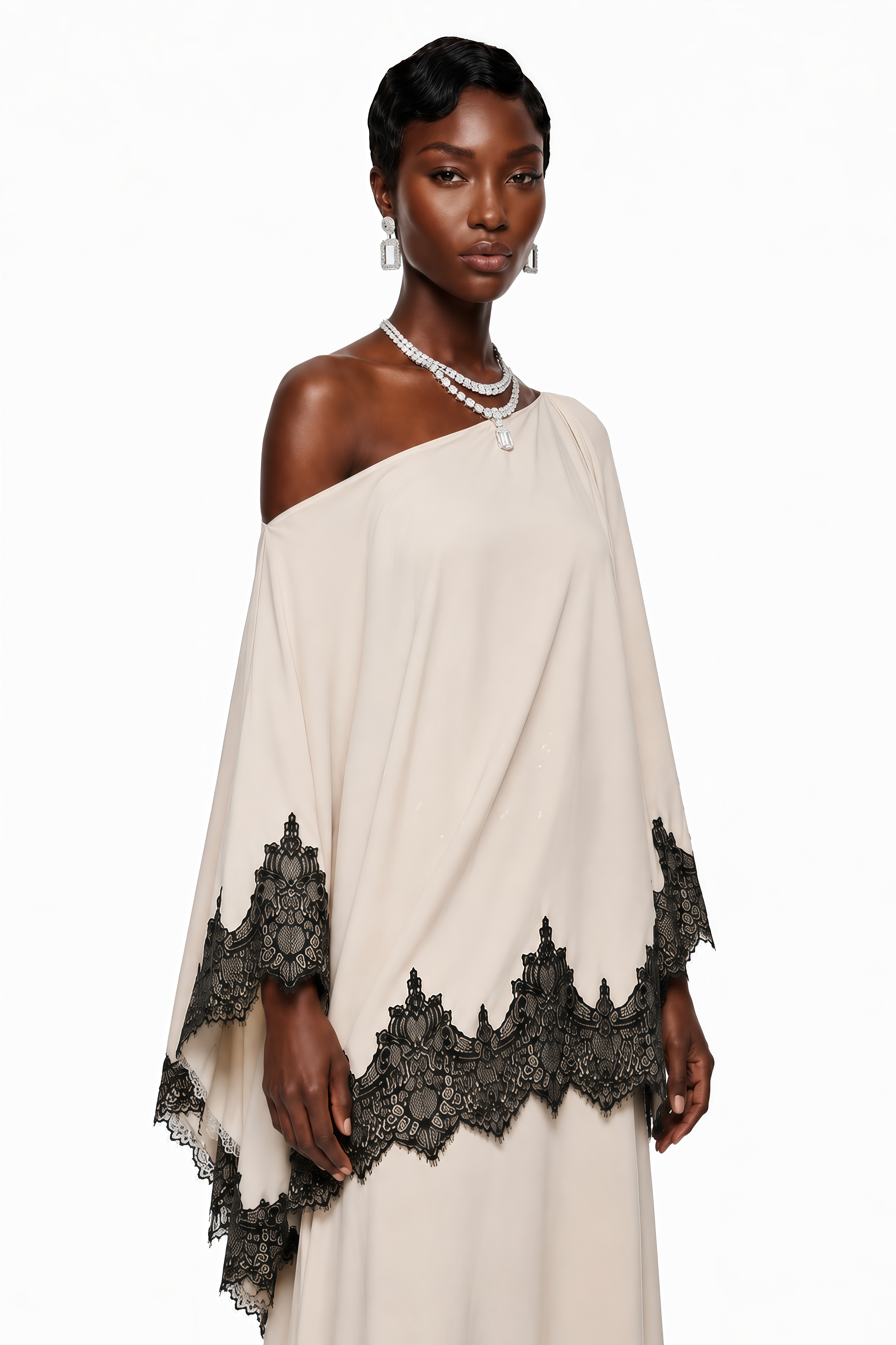 Cream one-shoulder maxi dress with an asymmetric black lace-trimmed cape and black lace-trimmed hem