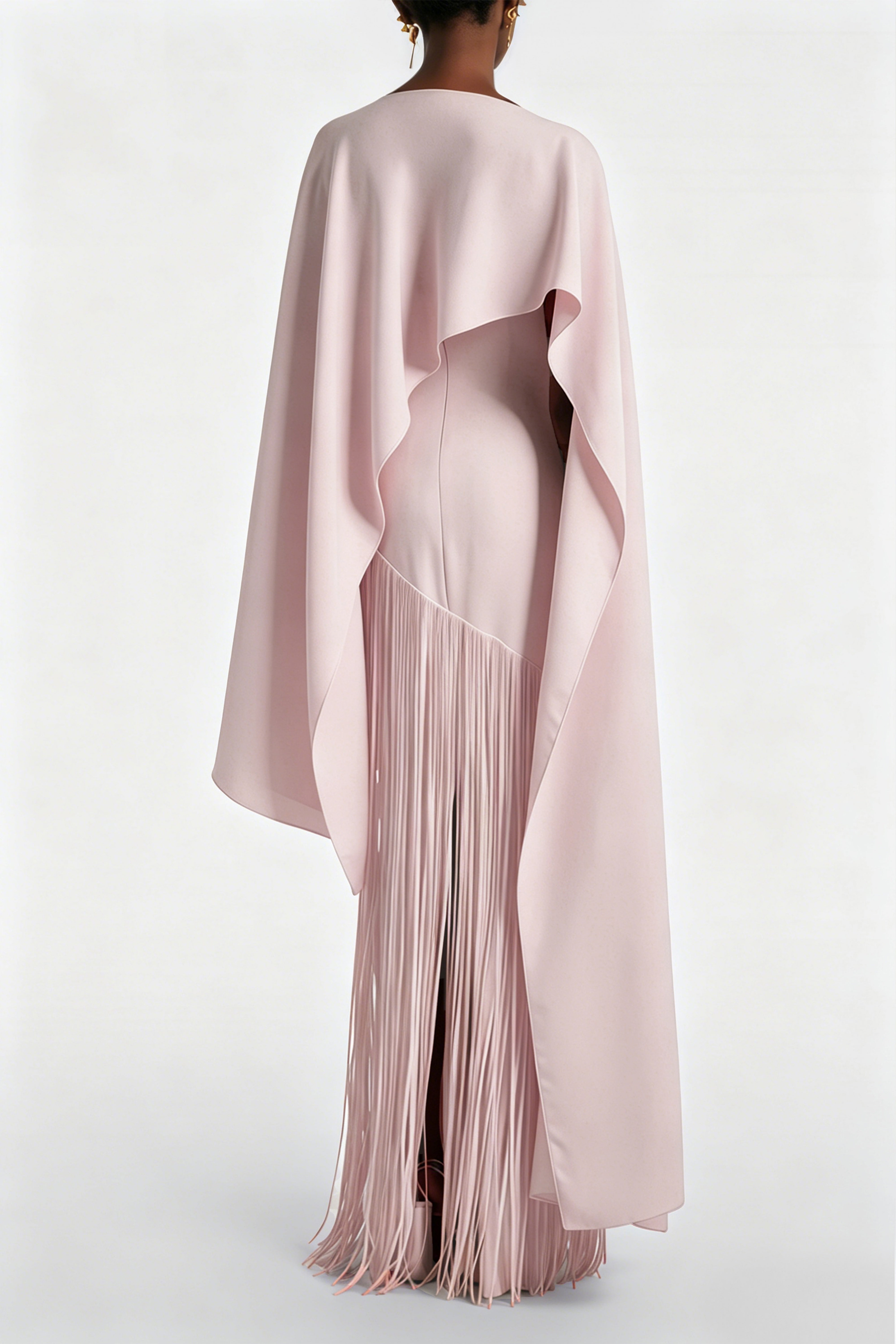 Light pink cape maxi dress with an asymmetrical waist and long fringe skirt