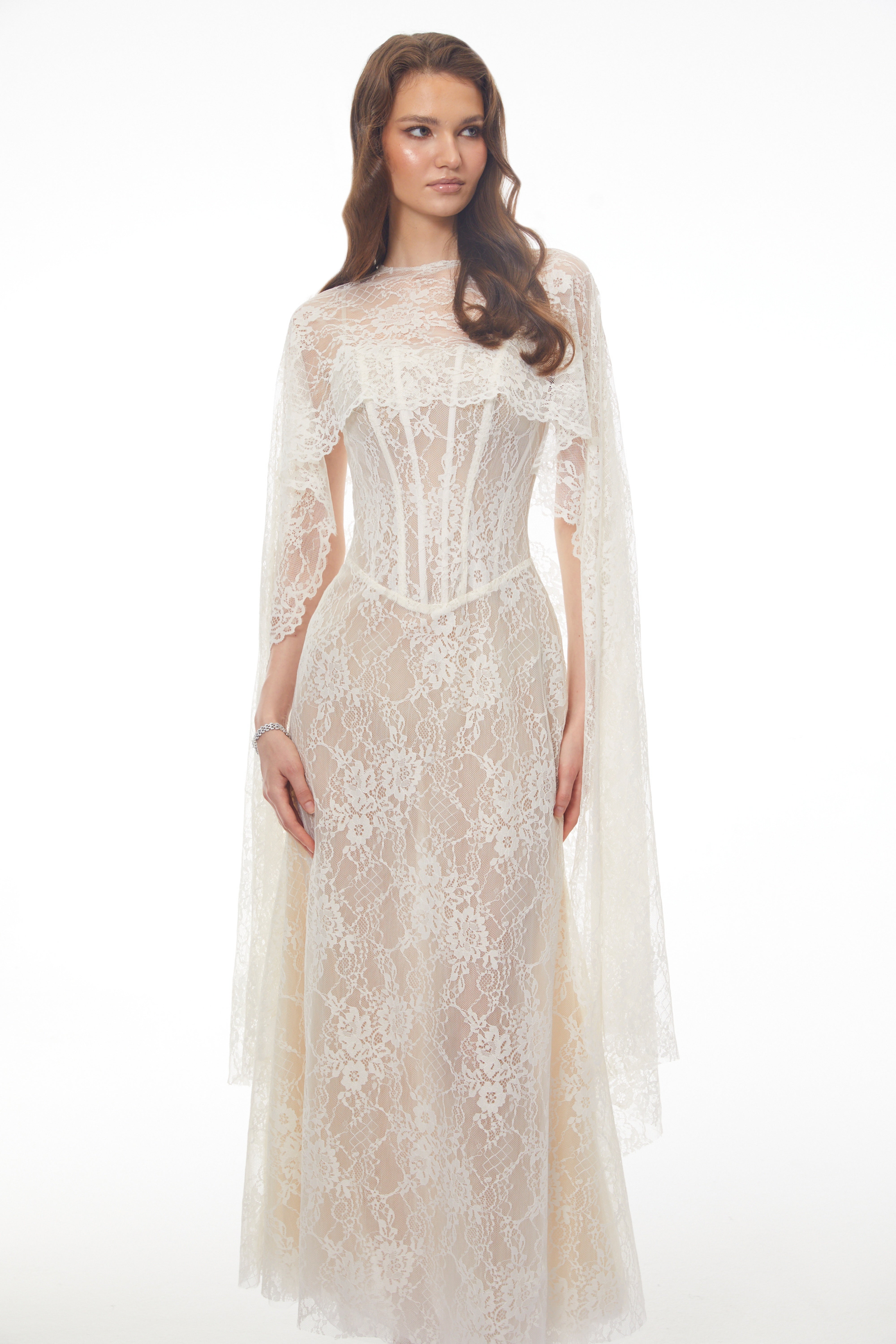 White lace maxi dress with a corset bodice, high neckline, and long draped cape sleeves