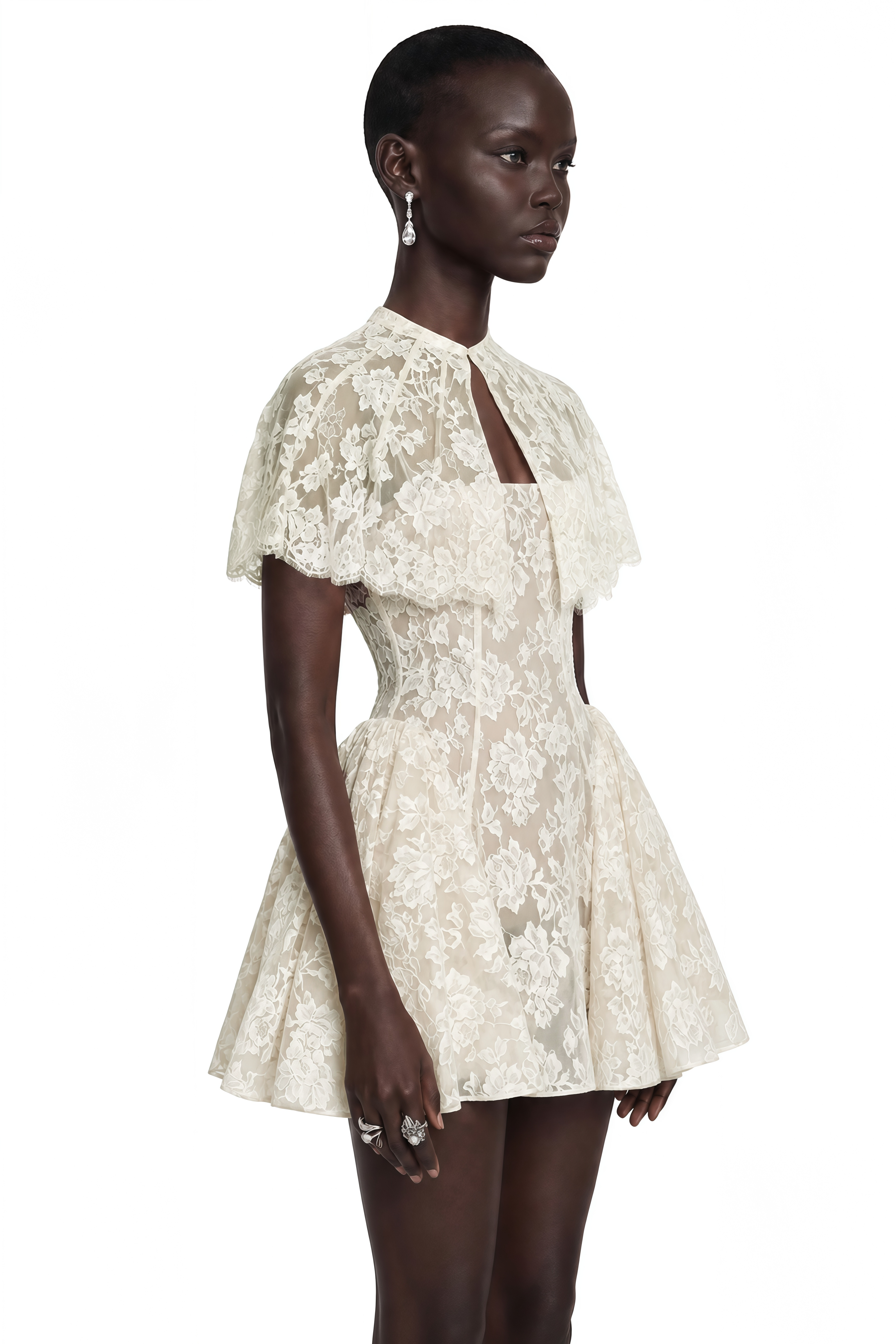 White lace mini dress with a structured flared skirt, keyhole neckline, and short flutter cape sleeves