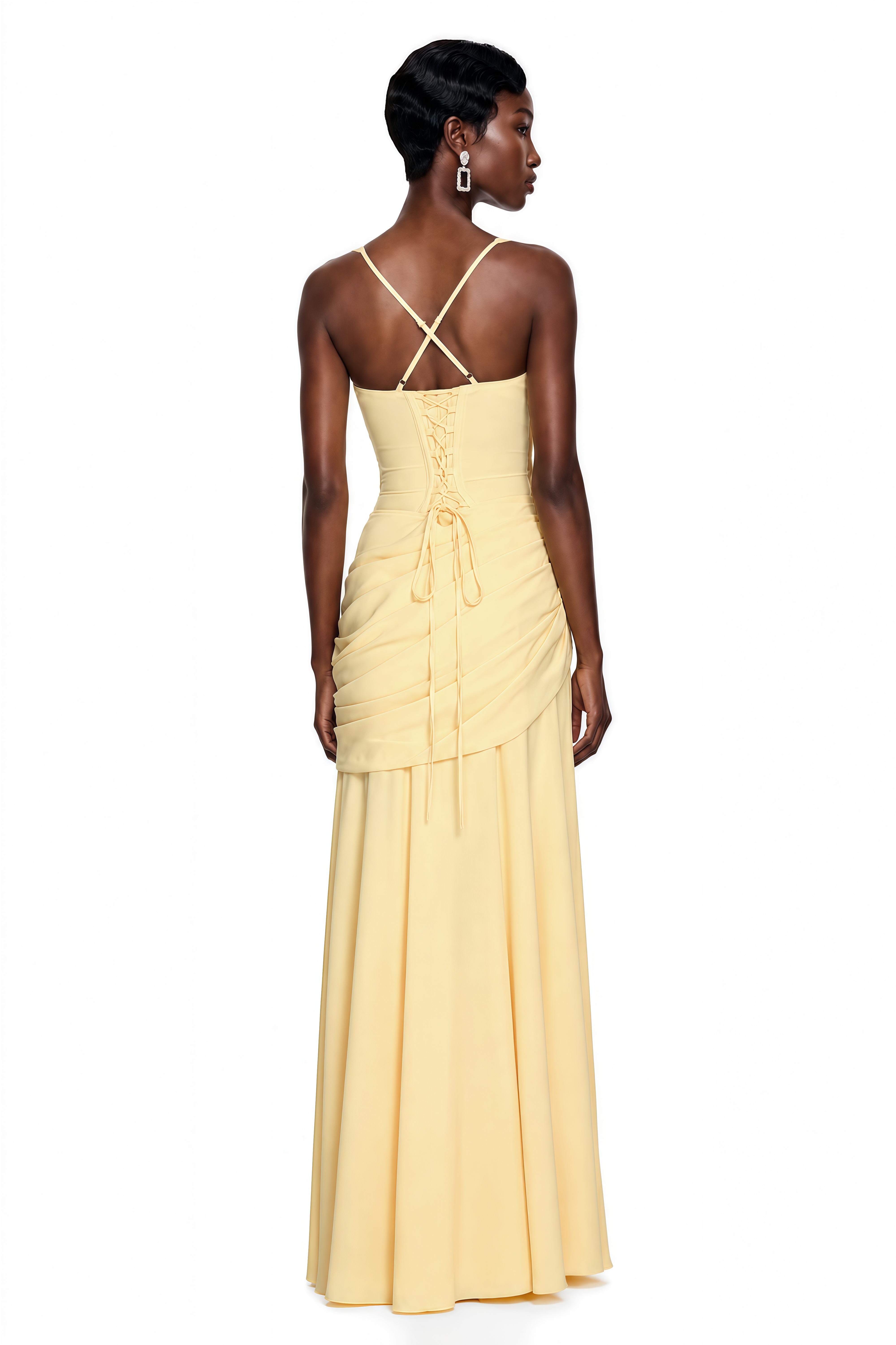 Yellow maxi dress with thick straps, a gathered corset bodice, and a draped asymmetric skirt